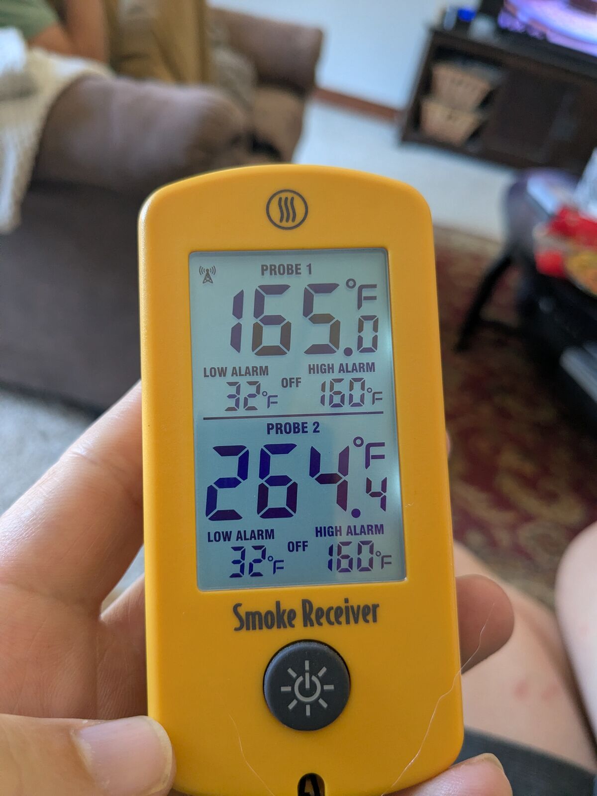 Smoke receiver held in hand showing meat at exactly 165.0°F and pit at 264.4°F.